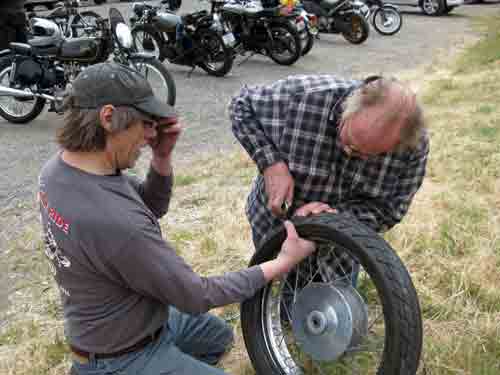 Mork pulls the screw out of the tire.