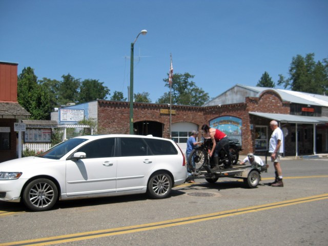 cross from the auto parts store, Kim takes her bike off the chase truck and prepares to ride again.